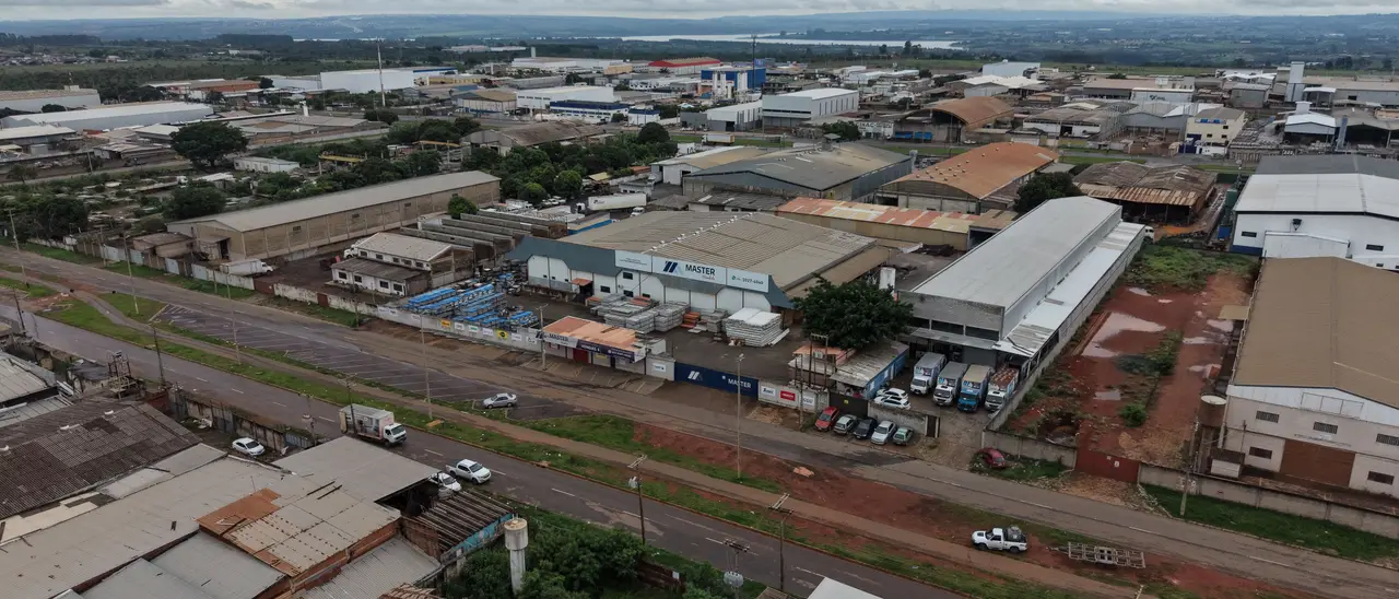 Vista aérea do Setor Industrial de Ceilândia, com o galpão da Master Atacadista e a frota de caminhões